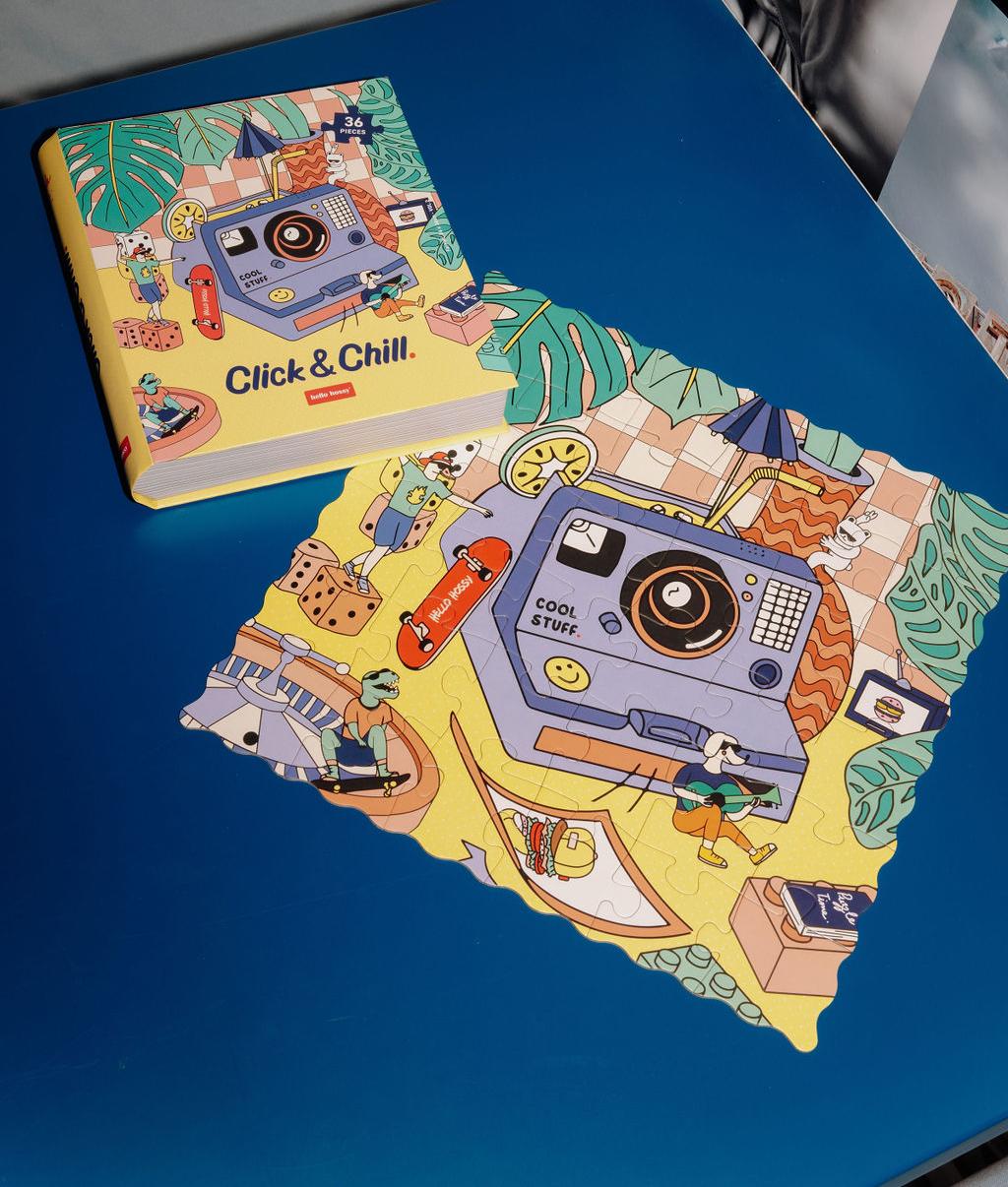 Puzzle coloré "Click & Chill" assemblé sur une table avec la boîte à côté - vue du dessus - Hello Hossy