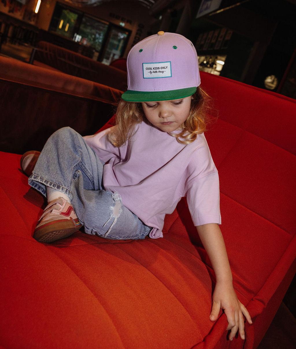 Roze kinderpet met groene klep gedragen Hello Hossy