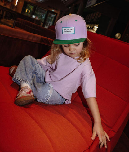 Roze kinderpet met groene klep gedragen Hello Hossy