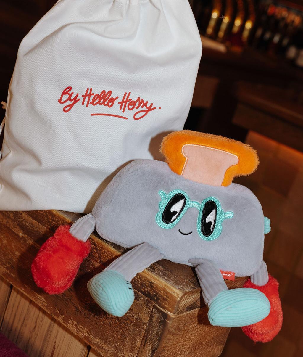 Peluche enfant Punchy Toast posée à côté de son pochon réutilisable - photo d'ambiance - Hello Hossy