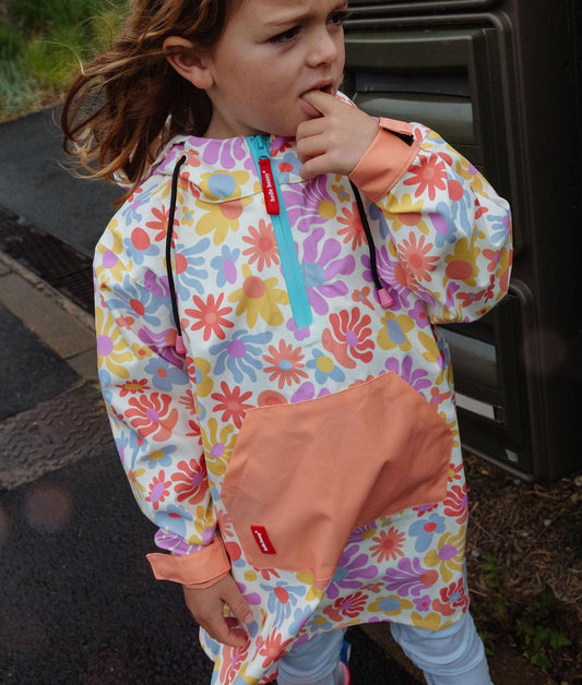Enfant portant le poncho de pluie imperméable avec capuche Retro Flowers – vue de face – Hello Hossy